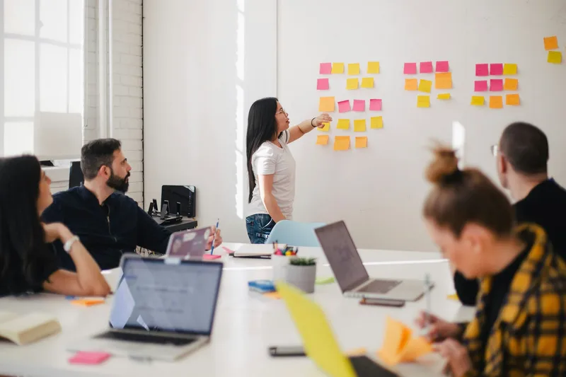 An agency team in a meeting in front of a board with sticky notes